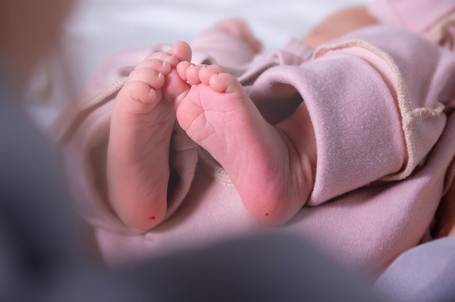 Newborn infant's foots and heel prick, PKU phenylketonuria test. Blood draw puncture. Guthrie' test for congenital genetic diseases. Close up.